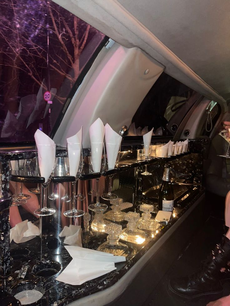 the interior of a limo with wine glasses and silverware on it's counter