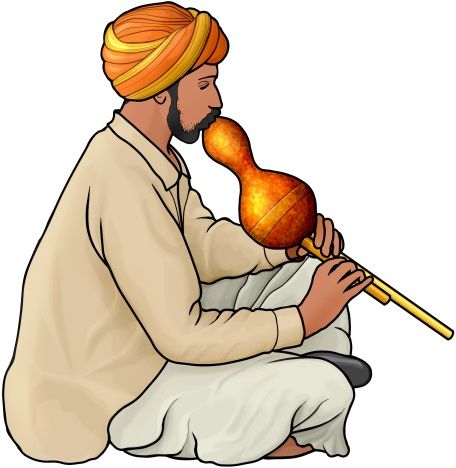 a man sitting on the ground with a pipe in his mouth and wearing an orange turban