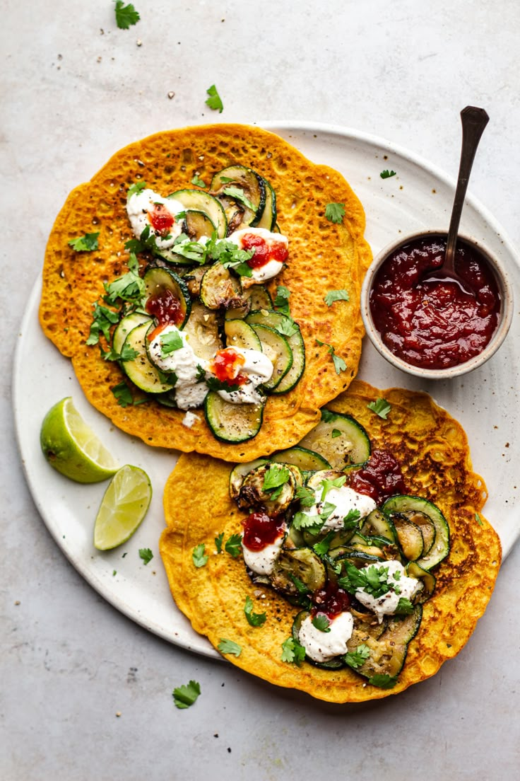 two tortillas with cucumbers and sauce on a plate