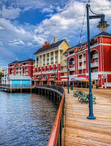 the boardwalk is lined with red and yellow buildings on either side of the water in front of a pier