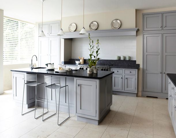 a large kitchen with gray cabinets and black counter tops