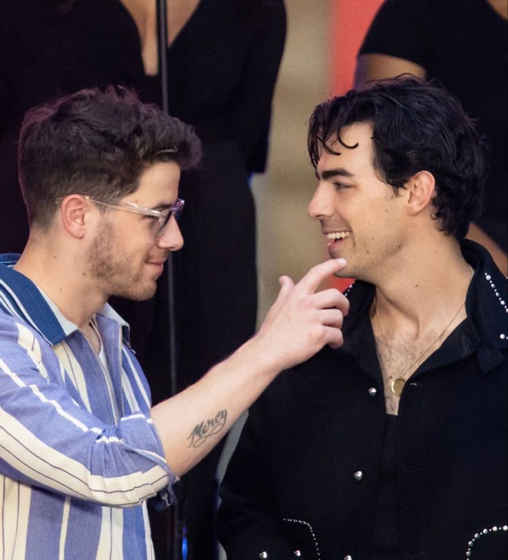 two men standing next to each other talking