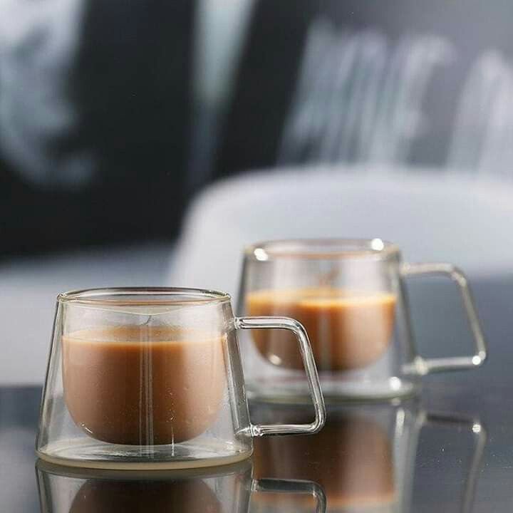 two mugs sitting on top of a table next to each other with liquid in them