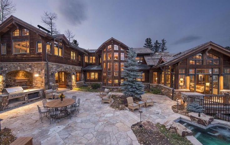 a large house with lots of windows next to a hot tub in the middle of it