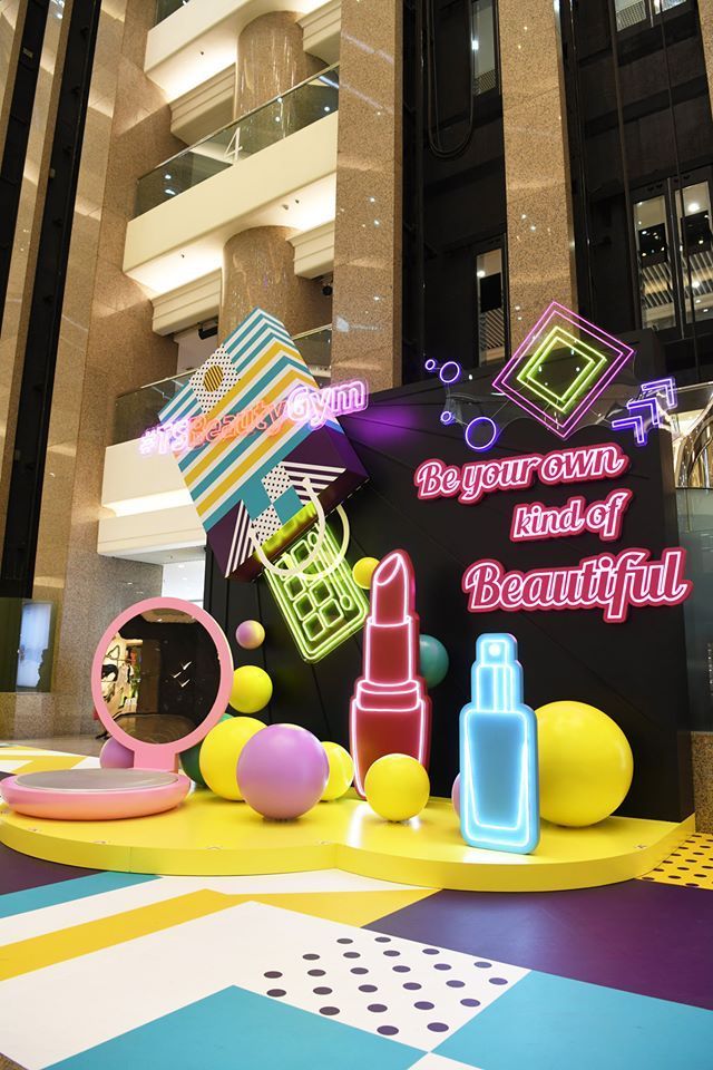 an assortment of makeup products displayed in front of a large sign that says, be your own kind of beautiful