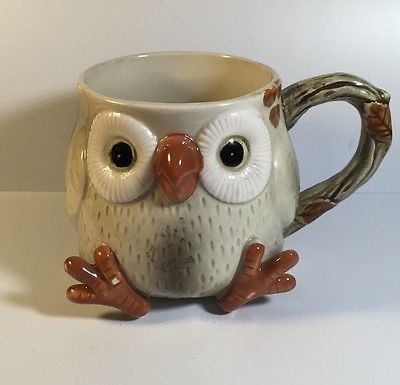 a ceramic owl mug sitting on top of a table