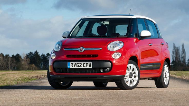 a small red car driving down a road