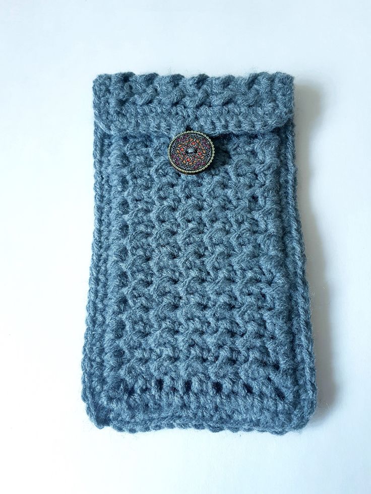 a crocheted blue case with a button on it