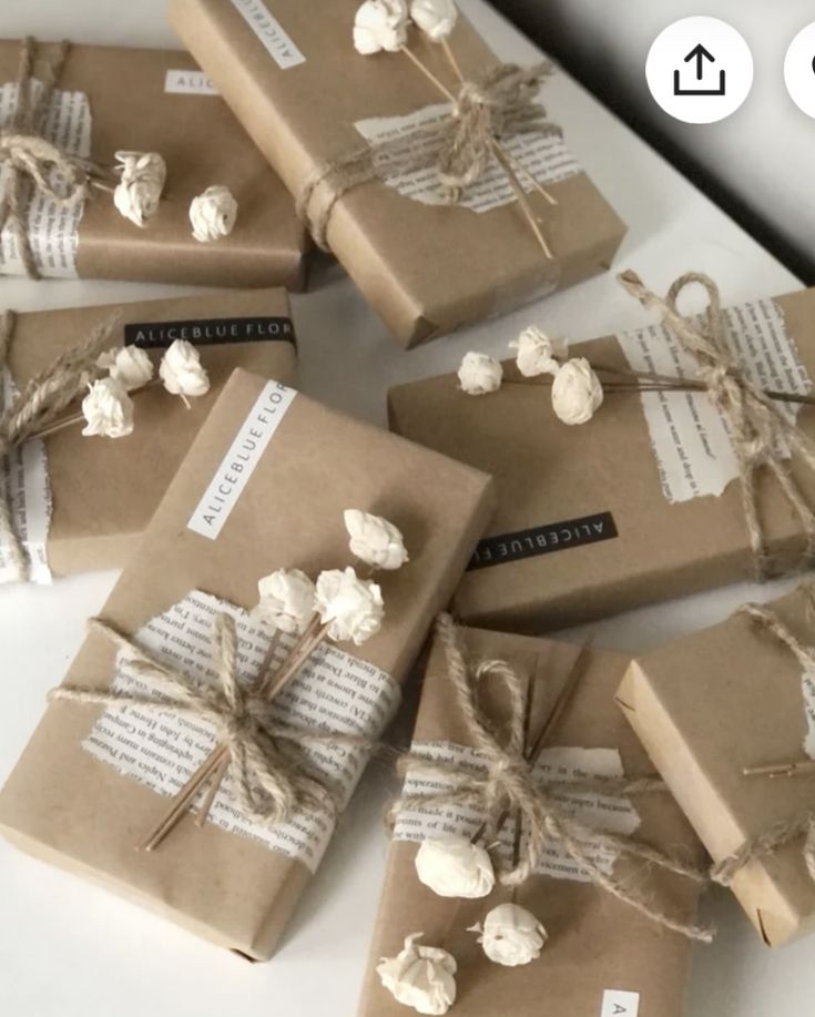 several wrapped presents with paper and twine tied around them on top of a table