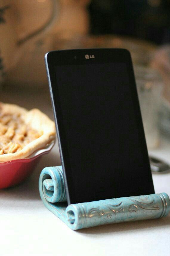 a cell phone sitting on top of a table next to a plate with pies