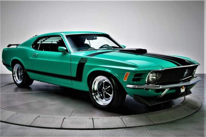 a green mustang muscle car on display in a museum