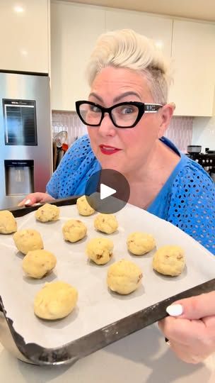 a woman holding a tray with cookies on it