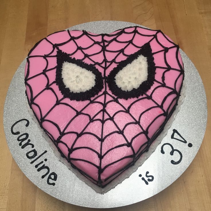 a heart shaped cake with spiderman's eyes on it