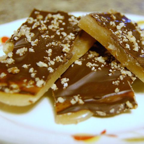 some kind of dessert on a white plate with brown sugar sprinkled around it