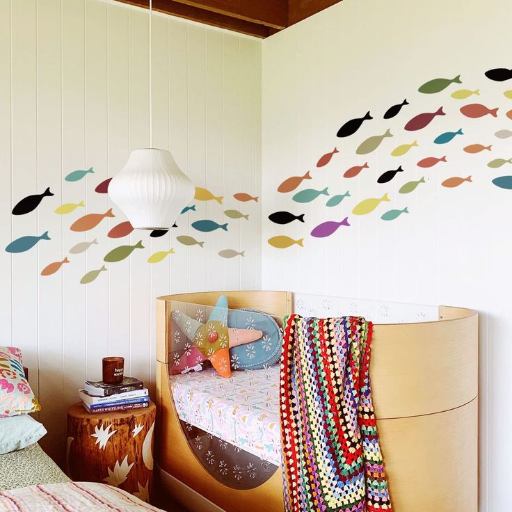 a child's bedroom with fish wall decals on the walls and bedding