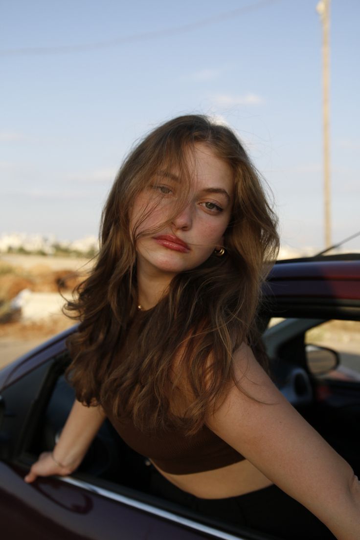 a woman leaning out the window of a car