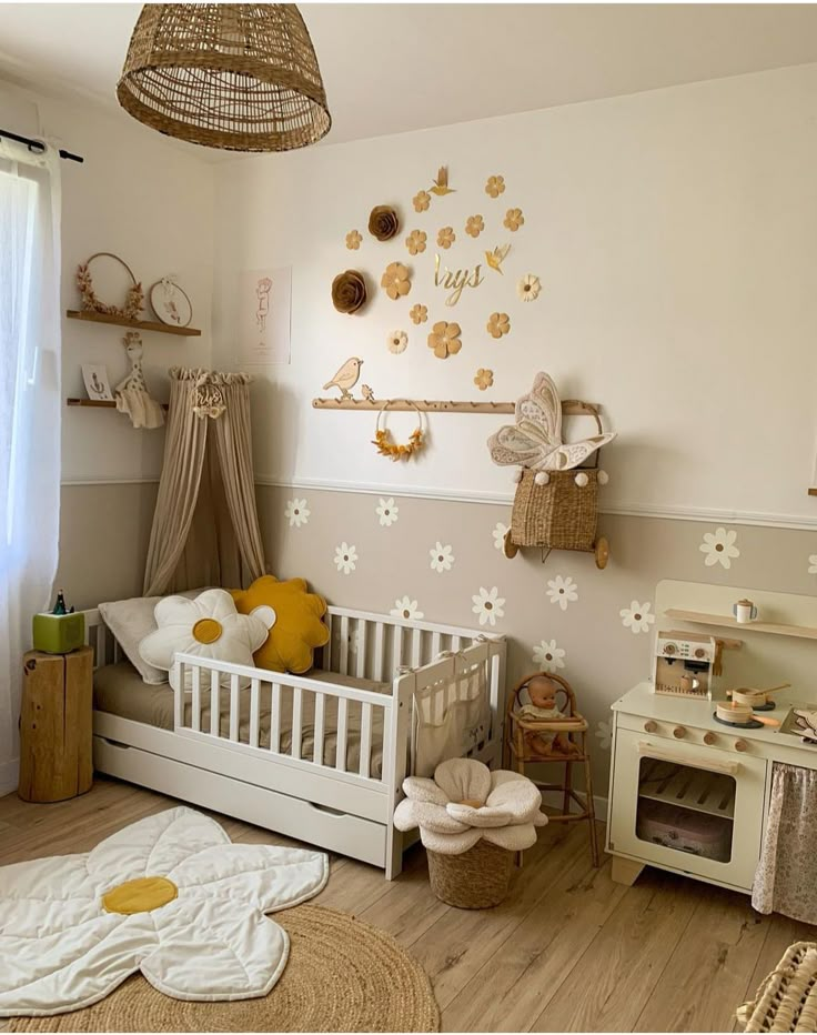 a child's room with white furniture and gold decorations on the wall, including a crib