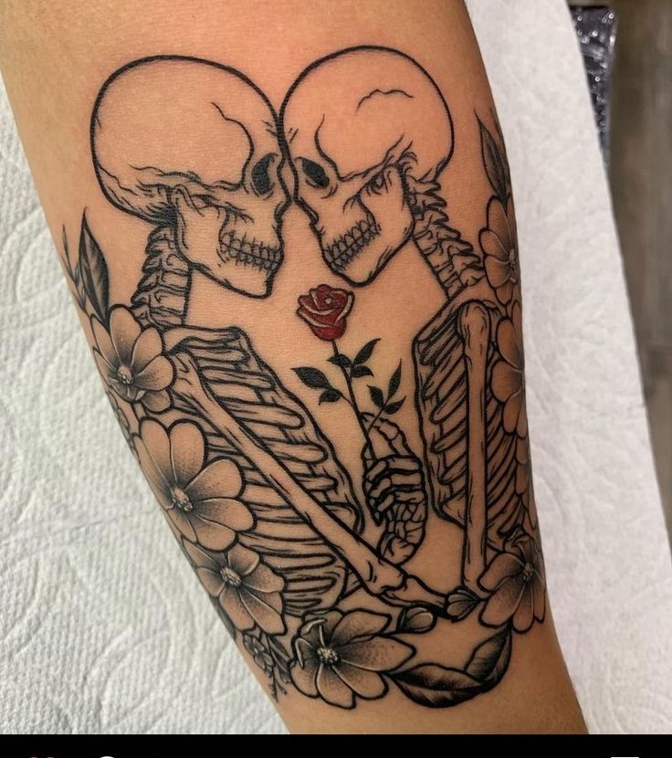 a couple of skulls sitting next to each other on top of a person's leg