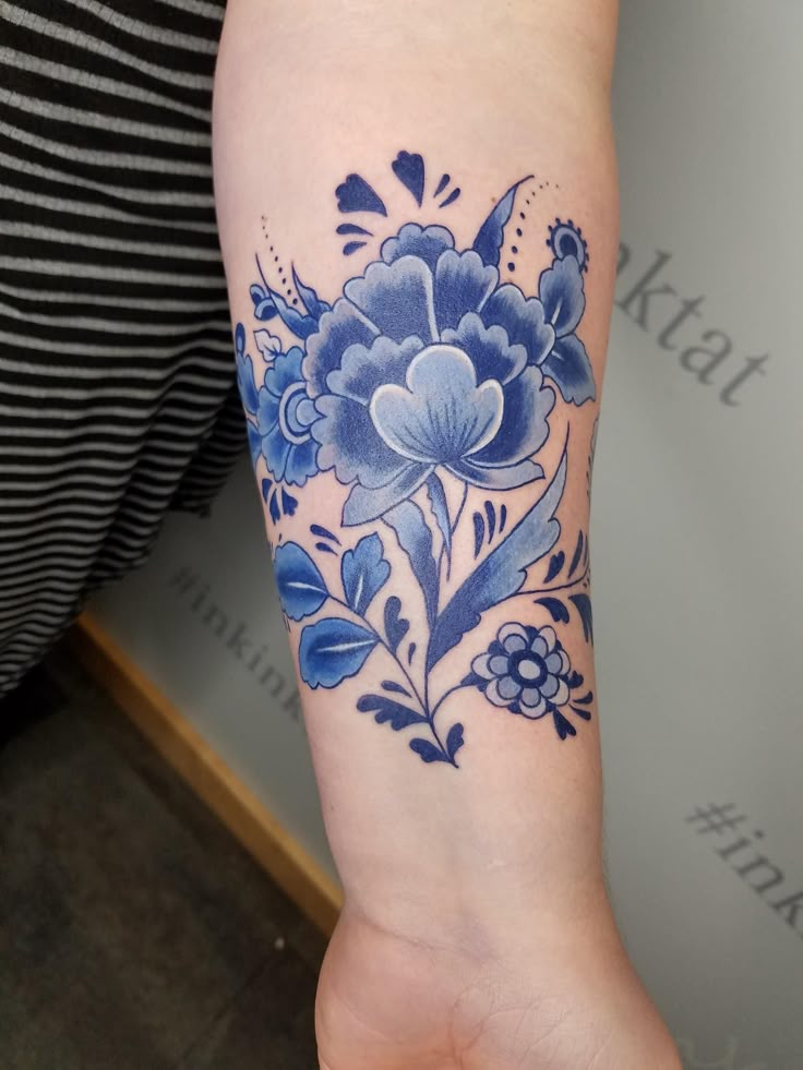 a woman's arm with blue flowers on it