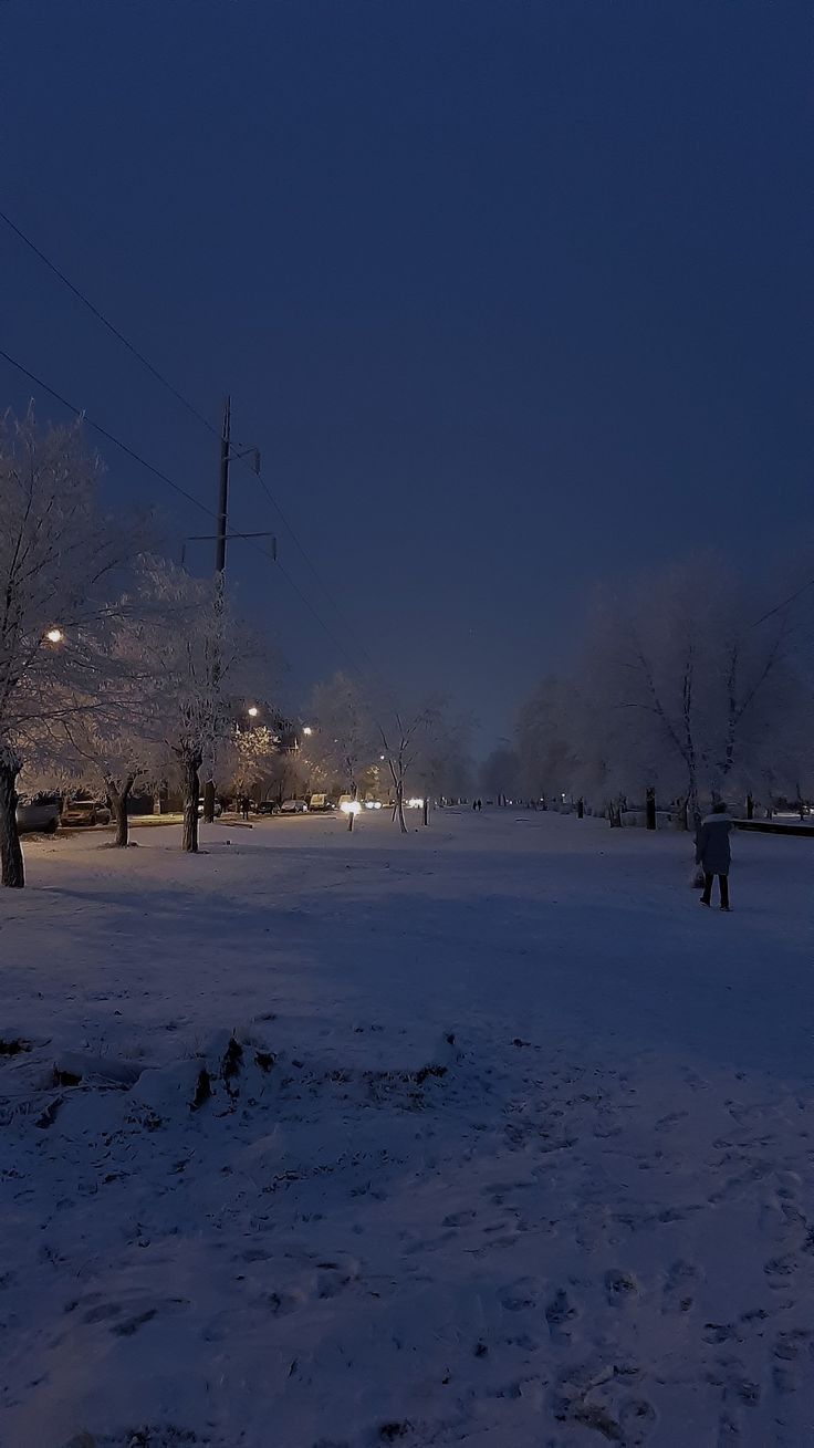 a person walking in the snow at night