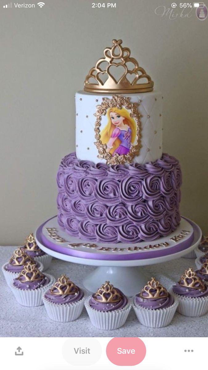 there is a purple and white cake with princesses on it, surrounded by cupcakes