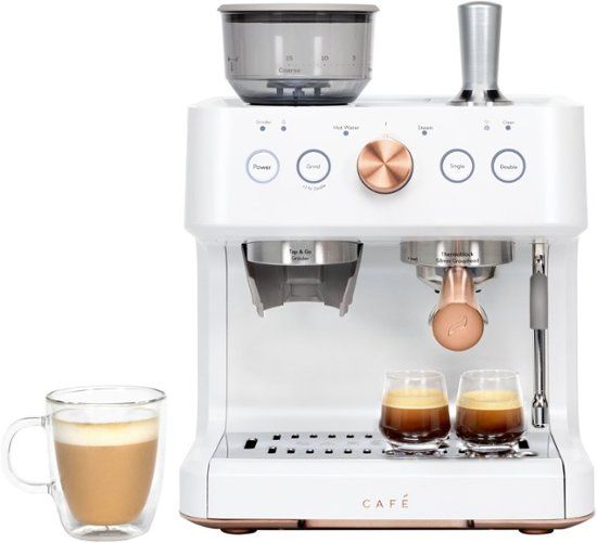 an espresso machine with two glasses next to it