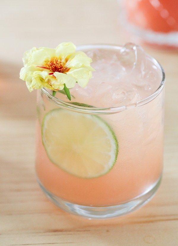 a close up of a drink on a table with a flower in the top half