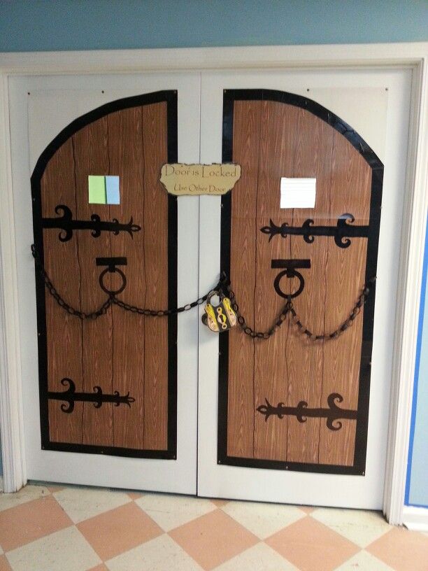 two wooden doors with chains and locks on them in front of a tiled flooring area