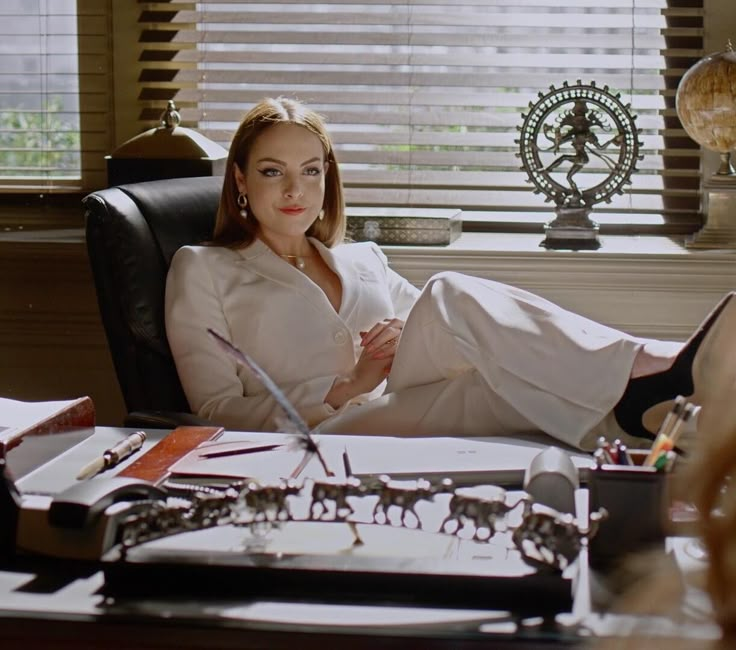 a woman sitting in a chair with her feet up on the desk, surrounded by office supplies