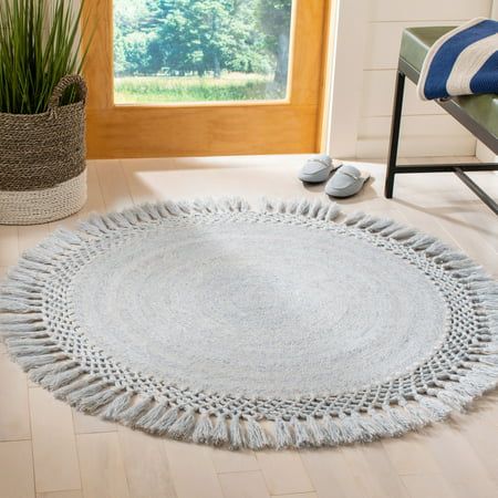 a white round rug with fringes on the floor