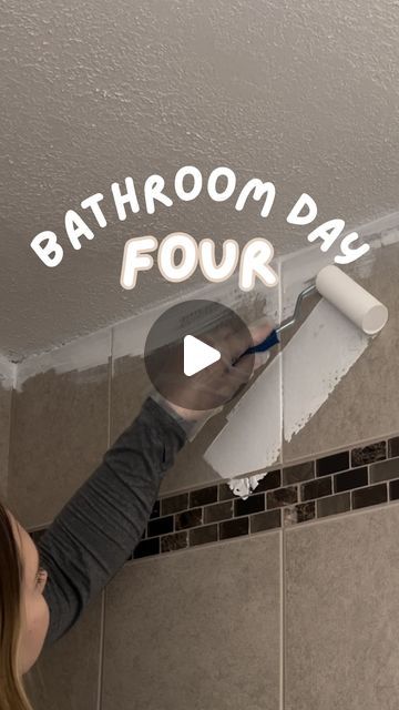 a woman is painting the ceiling with white paint and writing on it that says bathroom day four