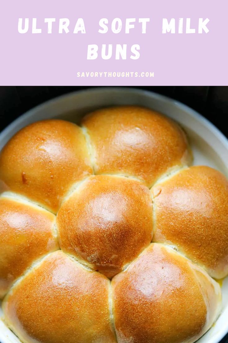 a white bowl filled with buns sitting on top of a table