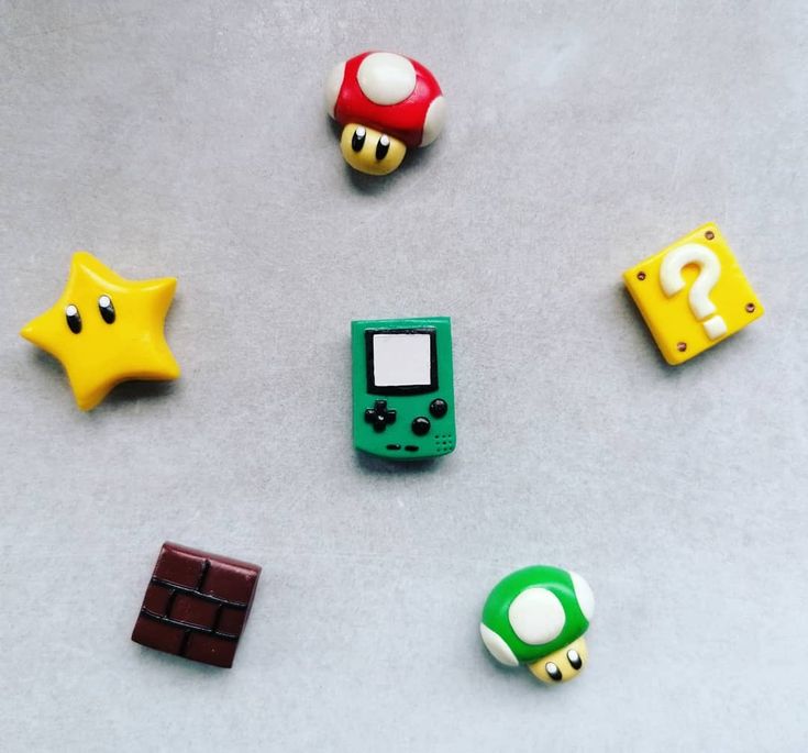 several nintendo gameboy toys are arranged on a table with one being a star, the other is a chocolate bar