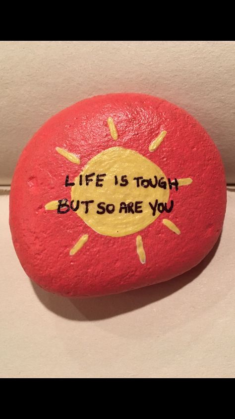 a red rock with the words life is tough but so are you written on it