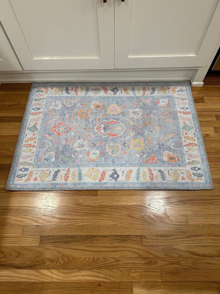 a rug on the floor in front of a cabinet