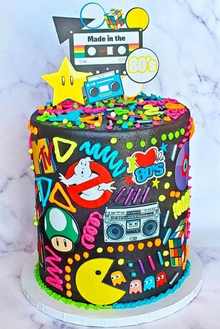 a multicolored cake decorated with an old school radio, boombox and stars