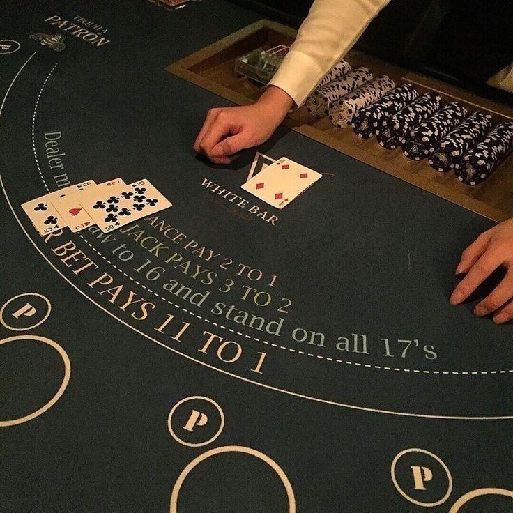 a blackjack table with playing cards on it and two people sitting at the table