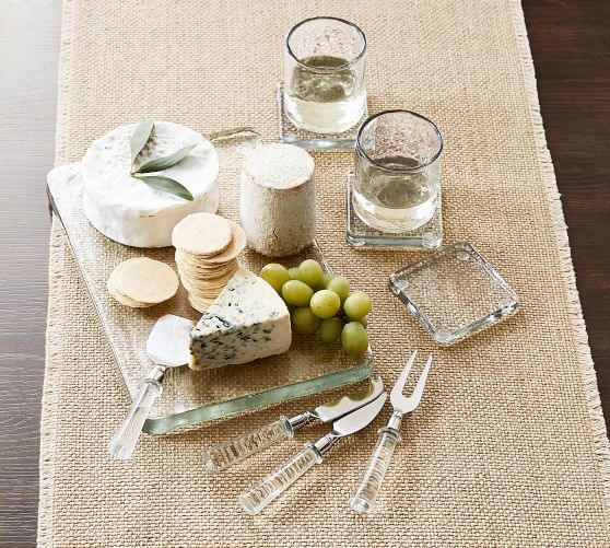 a table topped with cheese and crackers on top of a cloth covered place mat