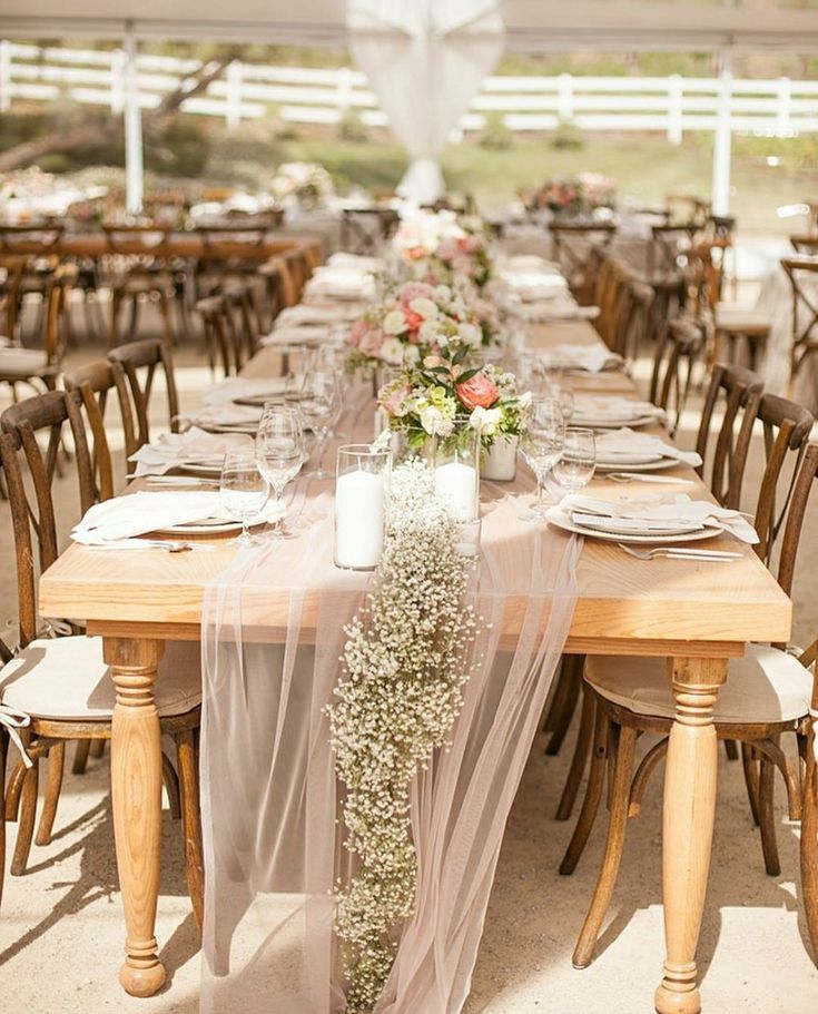 a long table is set with place settings and flowers