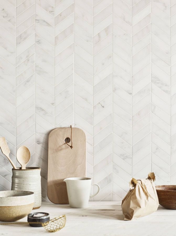 a kitchen counter topped with wooden spoons next to a bag and bowl on top of it