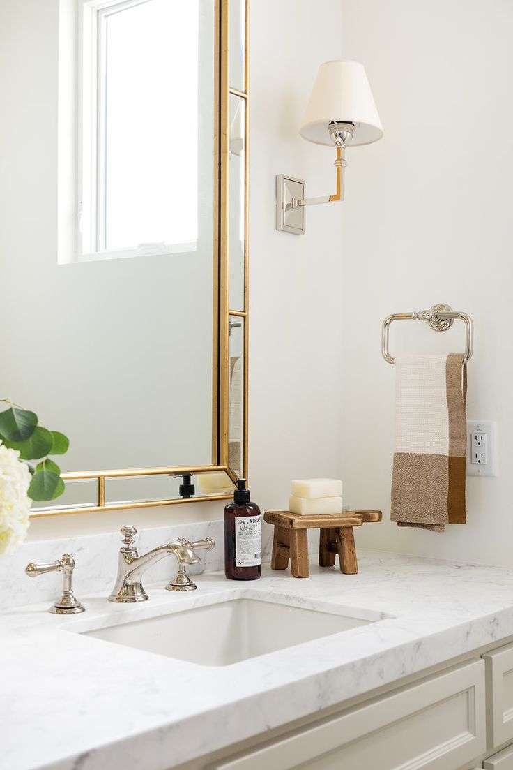 a bathroom with a sink, mirror and soap dispenser on the counter