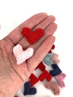 small crocheted hearts being held in someone's hand