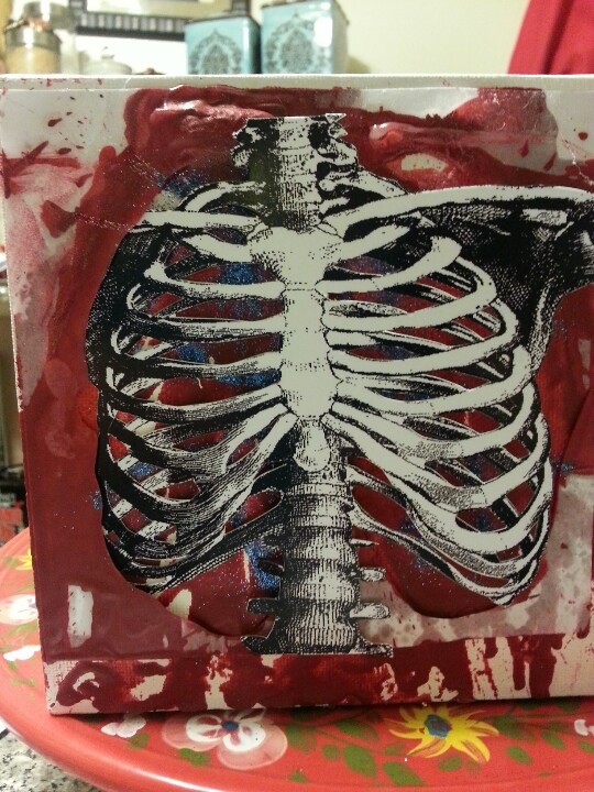 a red plate topped with a painting of a skeleton on it's back side