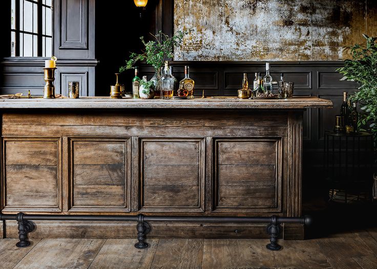 an old fashioned bar with lots of bottles on it's top and candles in the middle