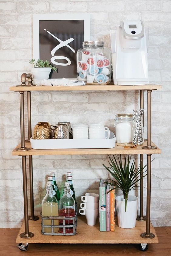 a shelf with various items on it in front of a brick wall and wooden floor