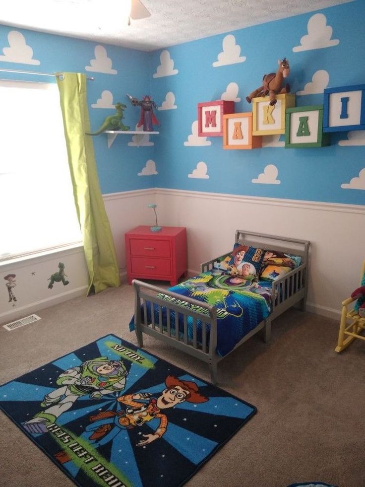 a child's bedroom decorated in blue and green with toy story characters on the walls