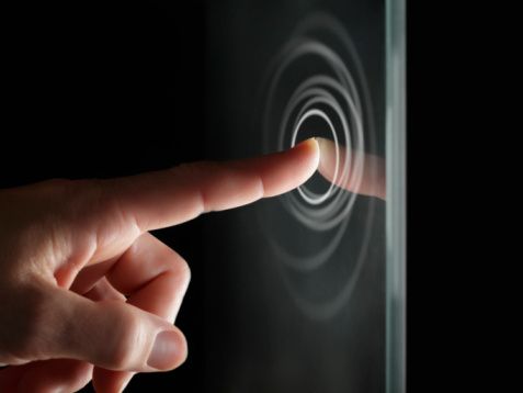 a person touching the screen with their finger in front of them and an image of a black background