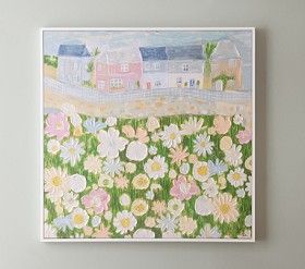 a painting hanging on the wall above a bed with flowers and houses in the background