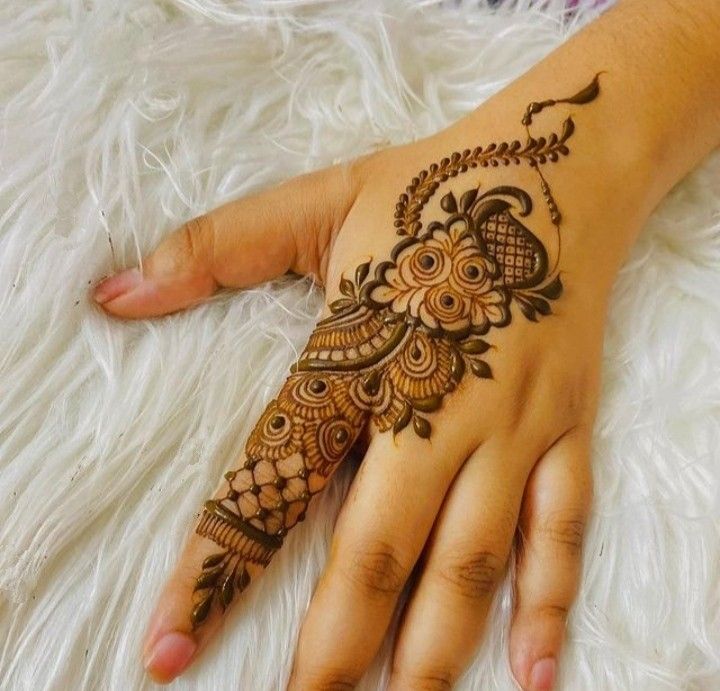 a woman's hand with henna tattoos on it