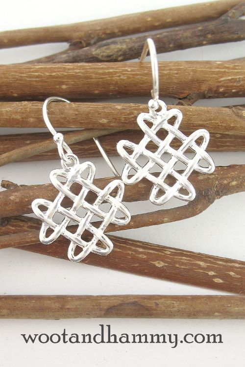 the earrings are made from silver wire and have an intricate design on them, as well as